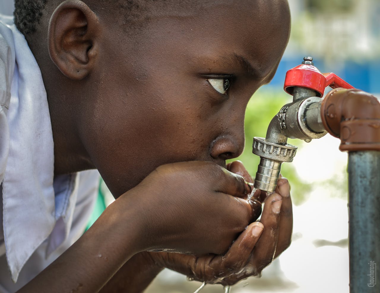 hero-img-02 Close-up of a child drinking water from a faucet in Mwanza, Tanzania.
