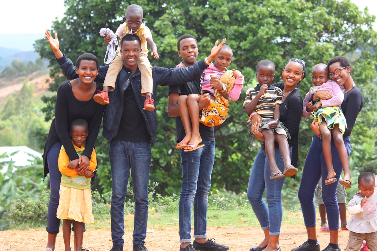 about-01 A vibrant and joyful group of family members celebrating together outdoors in Gitega, Burundi.